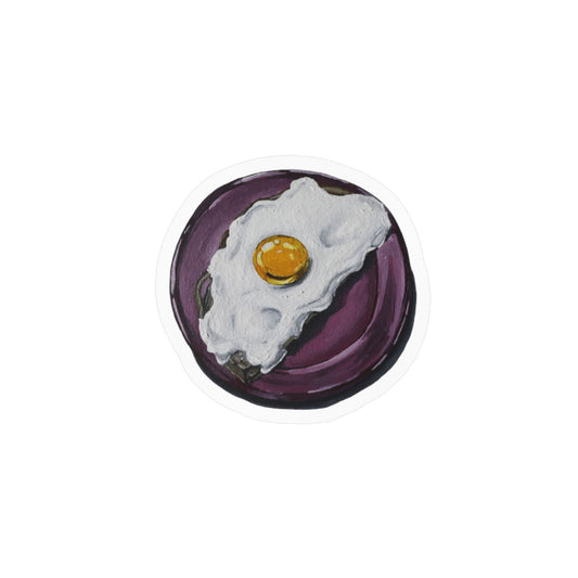 Egg kiss-cut vinyl sticker — playful hand-painted fried egg on a deep plum background, original art by Sachi Hash Studio